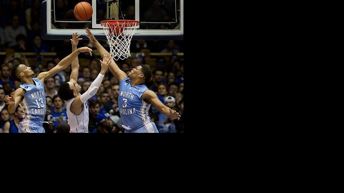 
Duke's Tyus Jones drives to the basket between North Carolina's Kennedy Meeks (3) and J.P. Tokoto (13) at Cameron Indoor Stadium in Durham, N.C., on Wednesday, Feb. 18, 2015. Duke won in overtime, 92-90.
