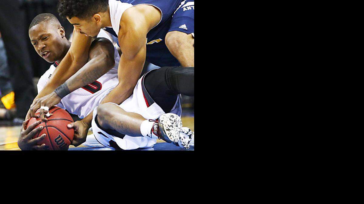 
Louisville’s Terry Rozier (0) and UC Irvine’s Aaron Wright (32) struggle for a loose ball in the first half during the second round of the NCAA Tournament at KeyArena in Seattle on Friday, March 20, 2015. Louisville advanced, 57-55. 
