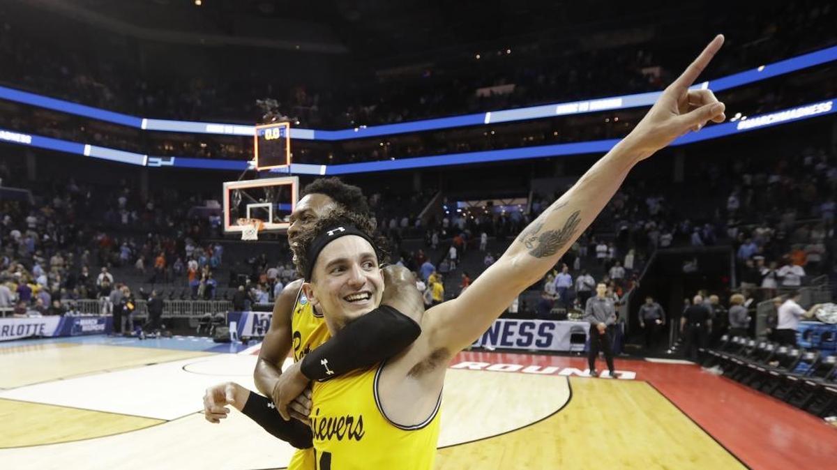 UMBC's K.J. Maura (11) and Jourdan Grant celebrate the team's 74-54 win over Virginia in a first-round game in the NCAA men's college basketball tournament in Charlotte, N.C., Friday, March 16, 2018. (AP Photo/Gerry Broome)