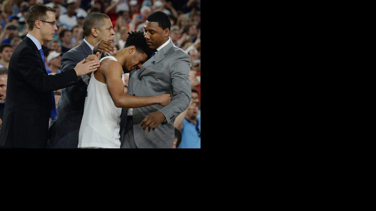 
Duke senior Quinn Cook is surrounded by the Blue Devil coaching staff of Jon Scheyer, Jeff Capel and Nate James as he is overcome with emotion making it into his first Final Four after Duke beat Gonzaga 66-52. 
