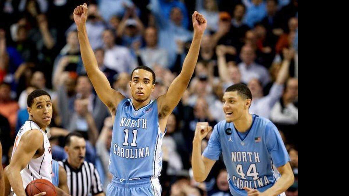 Virginia’s Malcolm Brogdon (15) leaves the court as North Carolina’s Brice Johnson (11) and Justin Jackson (44) celebrate the Tar Heels’ 71-67 victory over the Cavaliers <137>Virginia <137>on Friday, March 13, 2015 in the semifinals of the ACC<137>Atlantic Coast Conference<137> Basketball Tournament at the Greensboro Coliseum<137> in Greensboro, N.C<137>.