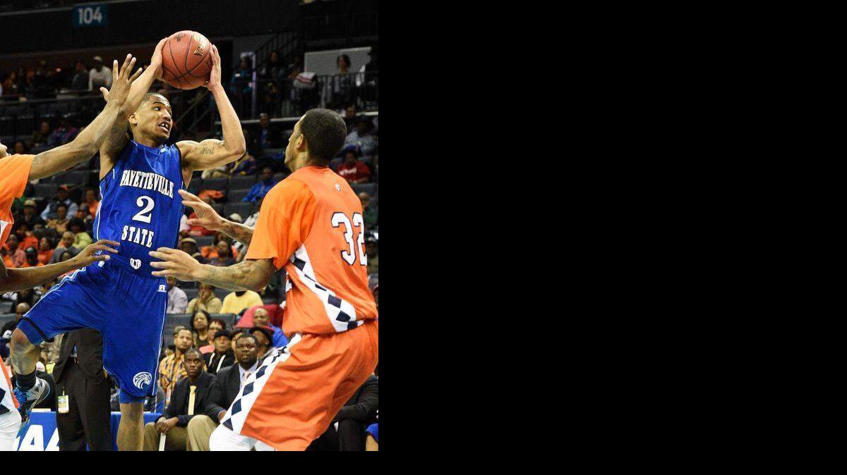 
Fayetteville State's Joshua Dawson passes off as he pulls up against Virginia State’s Alphonso Leary, right.
