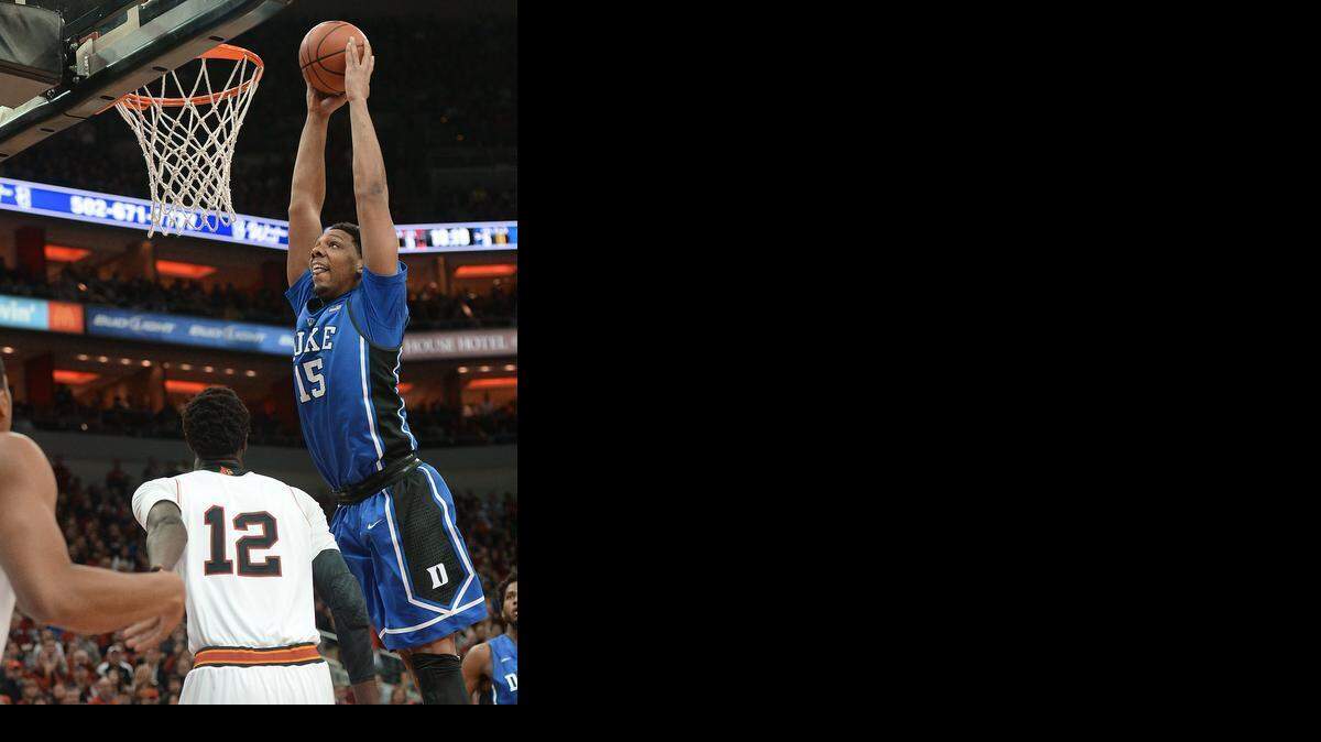
Duke center Jahlil Okafor goes in for thunderous first-half dunk as Louisville forward/center Mangok Mathiang looks on. Duke upset Louisville 63-52 on Jan. 17 at the KFC Yum! Center in Louisville, Ky. 
