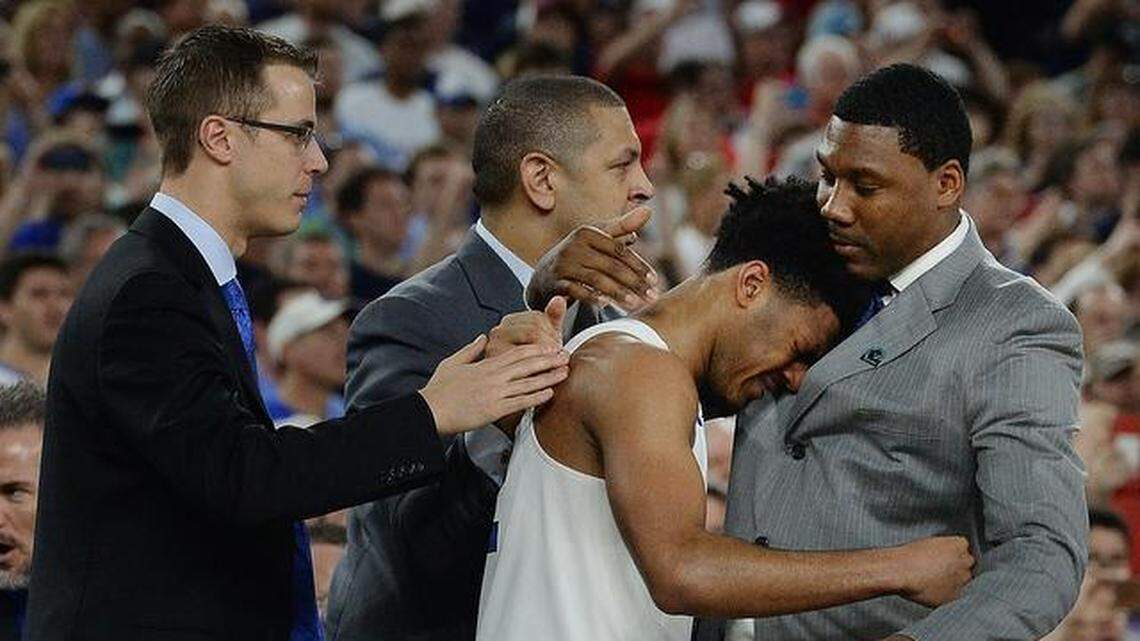 
Duke senior guard Quinn Cook (2) is surrounded by the Blue Devil coaching staff as he is overcome with emotion. Left to right are: Jon Scheyer, Jeff Capel, Cook, and Nate James.
