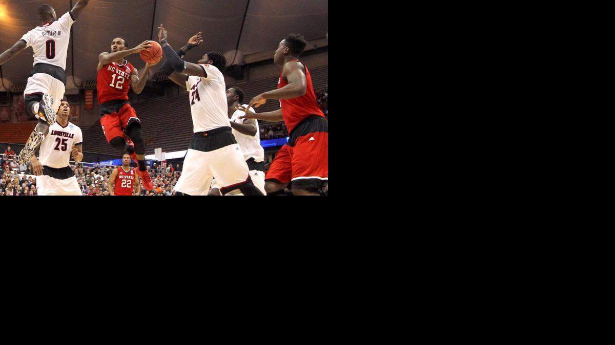 N.C. State's Cat Barber <137>(12) <137>drives to the basket between Louisville's Terry Rozier (0) and Montrezl Harrell (24) during the first half of the Wolfpack's game against Louisville in the semifinals of the NCAA East Region<137> of the 2015 NCAA Division I Men's Basketball Championship<137> at the Carrier Dome in Syracuse<137>, N.Y., Friday, March, 27, 2015<137>.