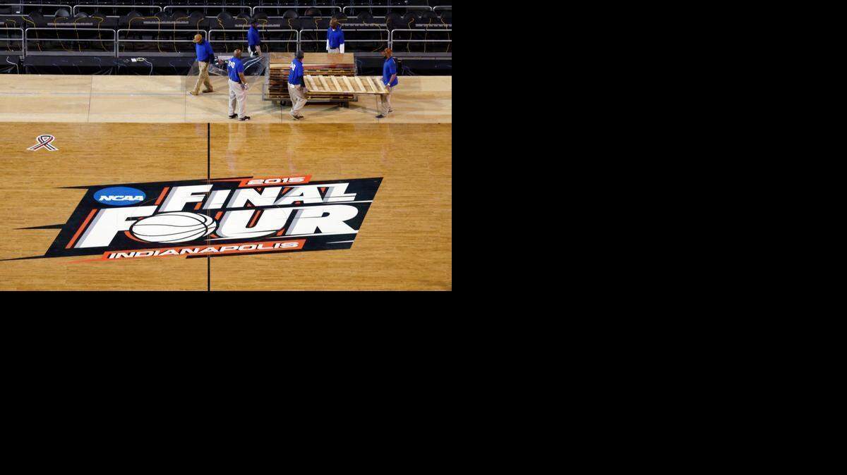 
Workers at Lucas Oil Stadium install the court in Indianapolis, Friday, March 27, 2015, as they prepare to host the NCAA Final Four college basketball games on April 4 and 6. (AP Photo/Michael Conroy) 
