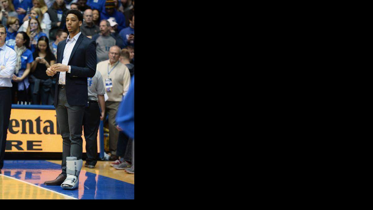 
Duke’s Jahlil Okafor watches as the team warms up for the Clemson game from the baseline in a boot at Cameron Indoor Stadium. He suffered an ankle injury in the first half against UNC Thursday night.
