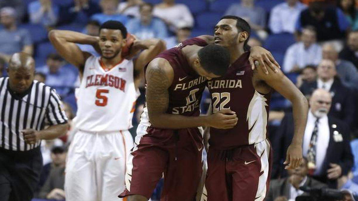 
Clemson’s Jaron Blossomgame (left) shows his disappointment as Florida State's Phil Cofer and Xavier Rathan-Mayes celebrate after the Seminoles’ 76-73 victory against the Tigers in the second round of the ACC men’s basketball tournament in Greensboro. 
