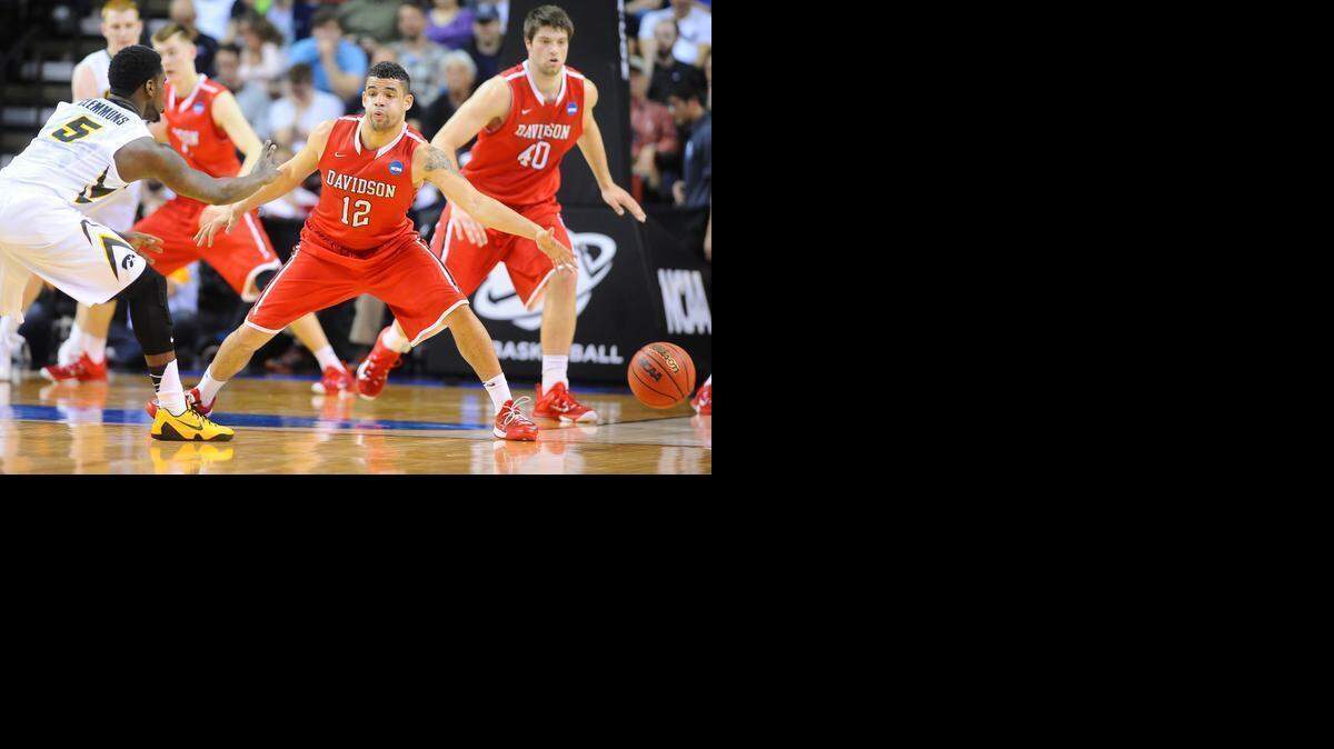 
Jack Gibbs (12) for the Wildcats defends against Iowa's Anthony Clemmons (5) in first half action as Davidson takes on Iowa in the 2015 NCAA Men's Basketball Championships at KeyArena on Friday, March 20, 2015 in Seattle, Washington. 
