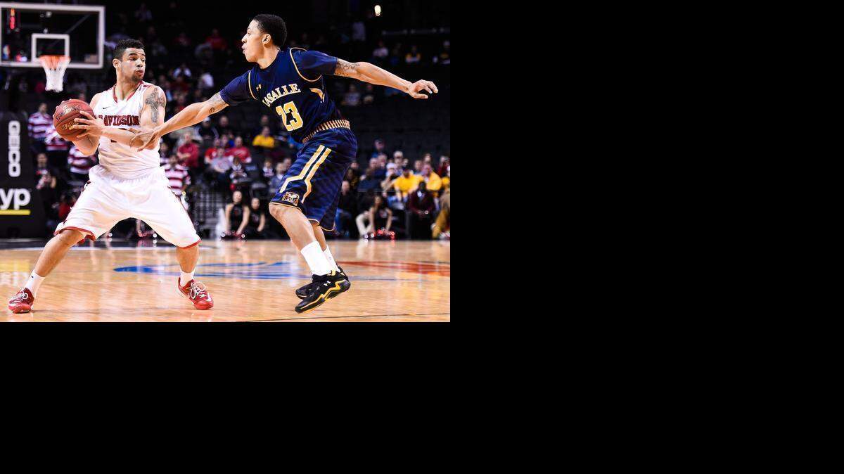 
Davidson’s Jack Gibbs (left) looks for an an open teammate as LaSalle’s Khalid Lewis defends during the quarterfinals of the Atlantic 10 men’s basketball tournament in Brooklyn, N.Y. Gibbs scored 22 points in the Wildcats’ 67-66 win. 
