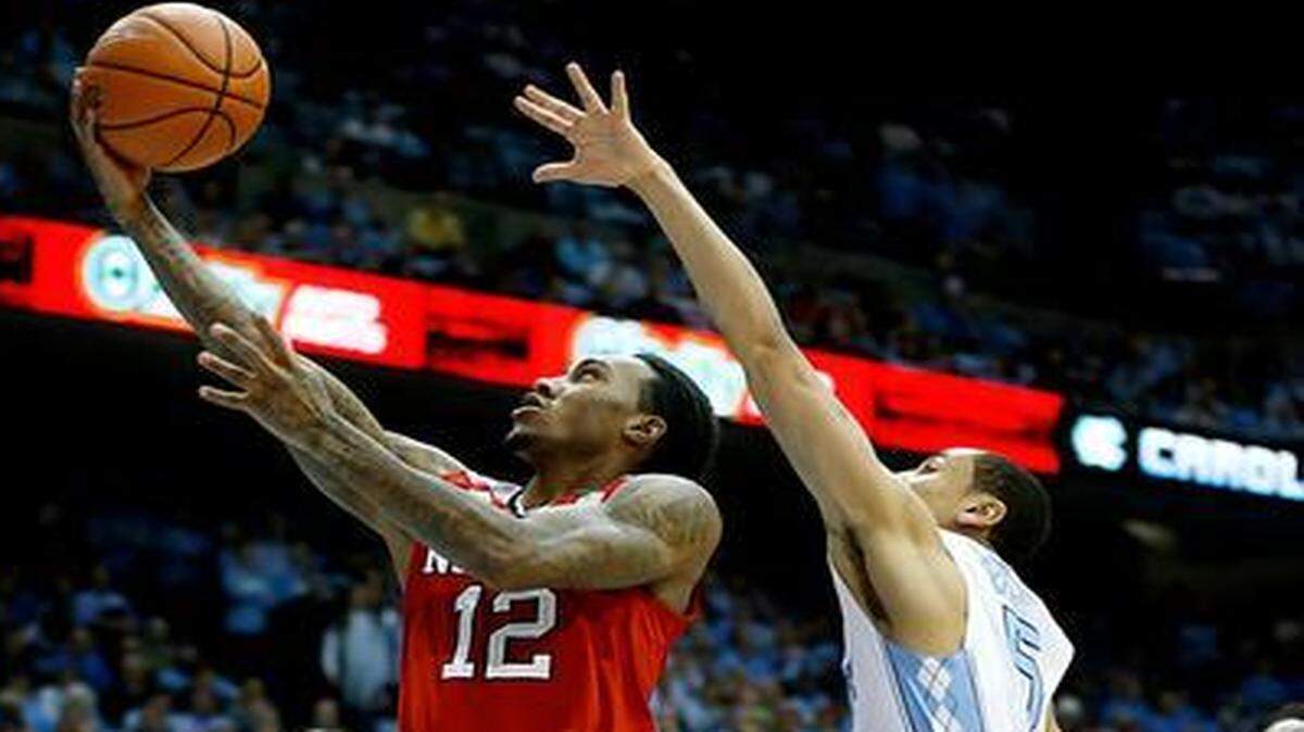 
N.C. State's Cat Barber (12) drives the basket past UNC's Marcus Paige (5) during the first half at the Smith Center in Chapel Hill.
