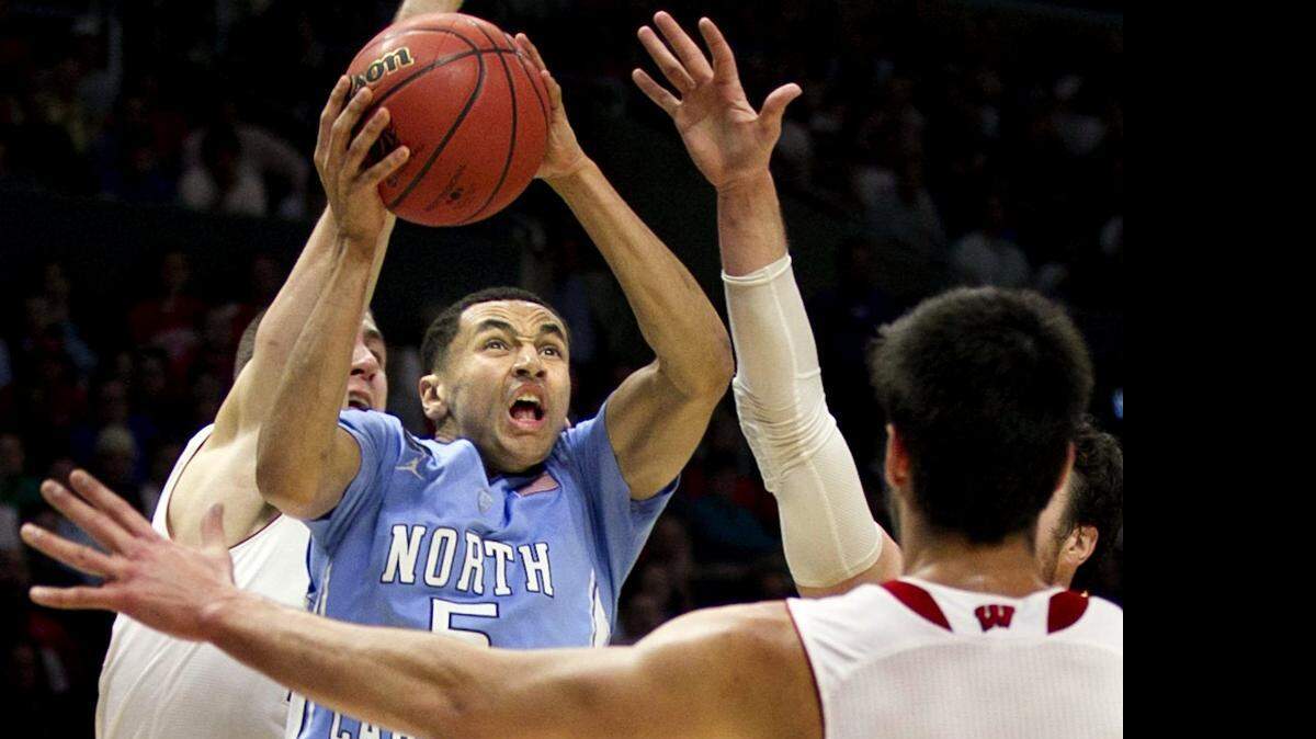 
North Carolina’s Marcus Paige (5) drives to the basket against Wisconsin’s Duje Dukan (13). Paige underwent arthroscopic surgery on his right ankle Monday.
