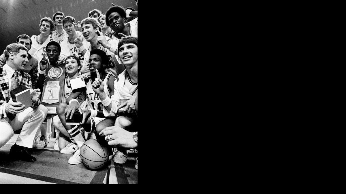 
N.C. State players pose with coach Norm Sloan, bottom left, and the 1974 national championship trophy, which is being held by David Thompson, after defeating Marquette 76-64 at the Greensboro Coliseum.

