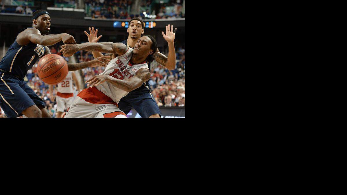 
N.C. State’s Cat Barber passes out of a double team by Pitt’s Jamel Artis (1) and Cameron Wright in the second half of play in the second round of the ACC Tournament at the Greensboro Coliseum.
