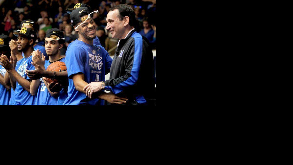 Duke senior Quinn Cook, second from right, and Coach Mike Krzyzewski embrace on stage after Cook spoke to a crowd of thousands at a welcome home celebration<137>. The Duke<137> of the Blue Devils basketball team <137>returned to campus heroes on Tuesday, April 7, 2015 after <137>winning the NCAA National Championship in Indianapolis the Monday night<137> before against the Wisconsin Badgers. Students and fans packed Cameron Indoor Stadium in Durham to celebrate the team's fifth national championship<137>.