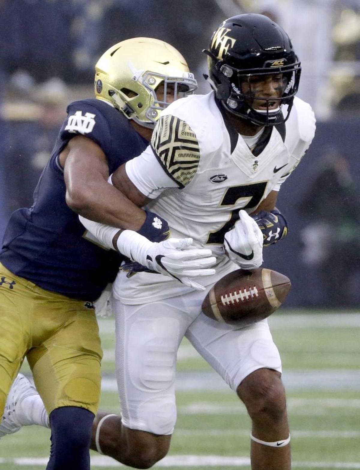 Wake Forest wide receiver Scotty Washington, right, is tackled by Notre Dame cornerback Julian Love during the first half of Saturday’s game in South Bend, Ind.