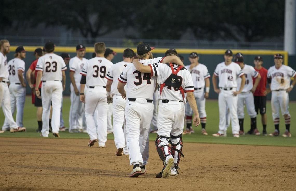 Davidson pitcher Durin O’Linger (34) and teammate James Padley hug after a 12-6 loss to Texas A&M in an NCAA college baseball tournament Super Regional game on June 10 in College Station, Texas.