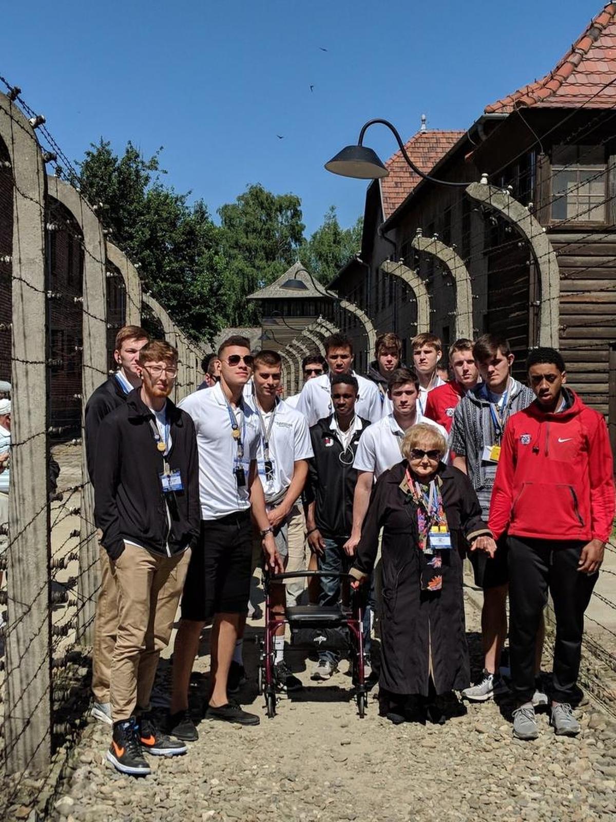Davidson’s basketball team posed with concentration camp survivor Eva Moses Kor at Auschwitz/Berkenau in Poland.