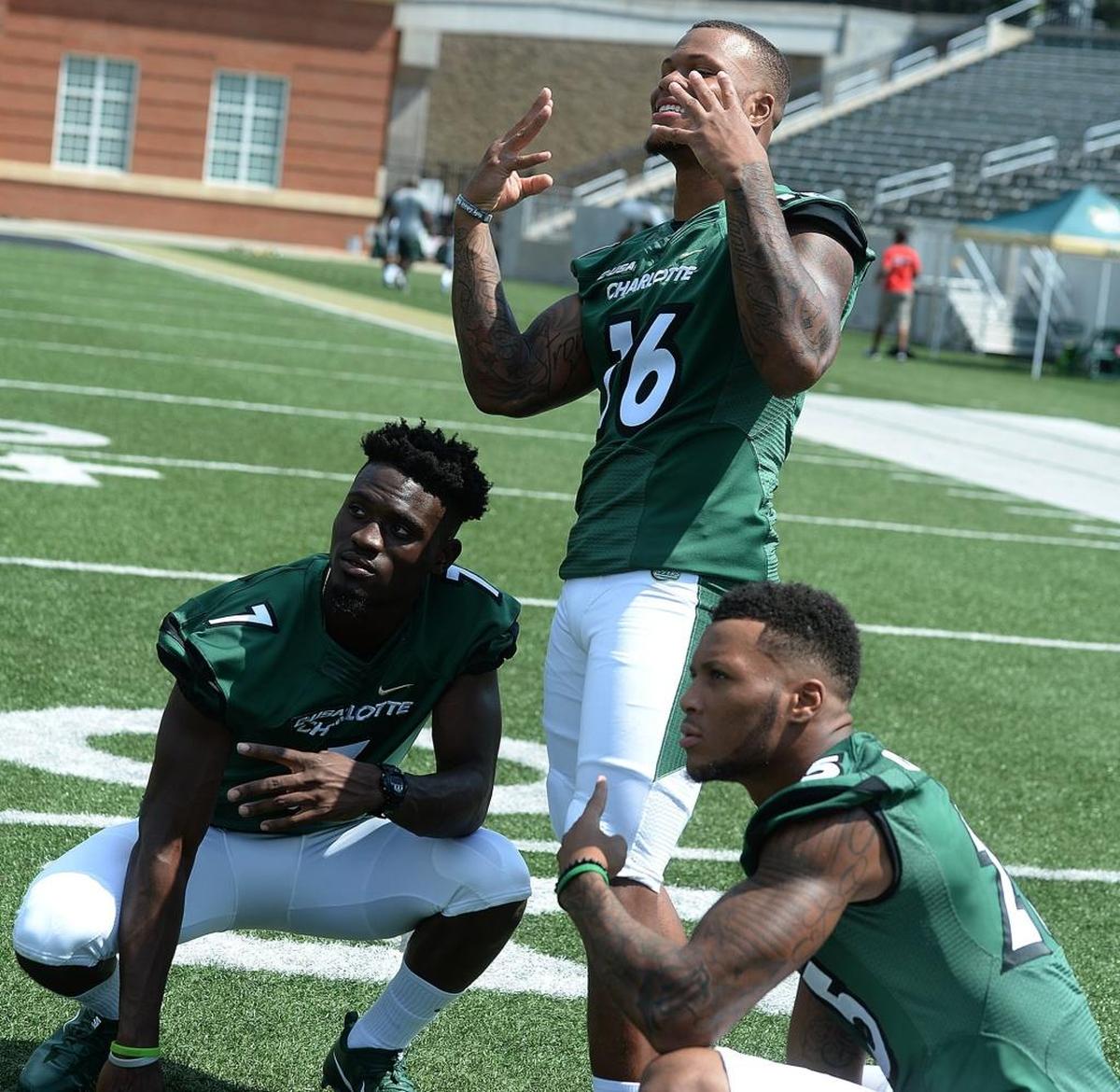 Charlotte 49ers quarterback Hasaan Klugh, linebacker Darius Irvin and defensive back Denzel Irvin pose for a photo at Saturday’s media day at Richardson Stadium.