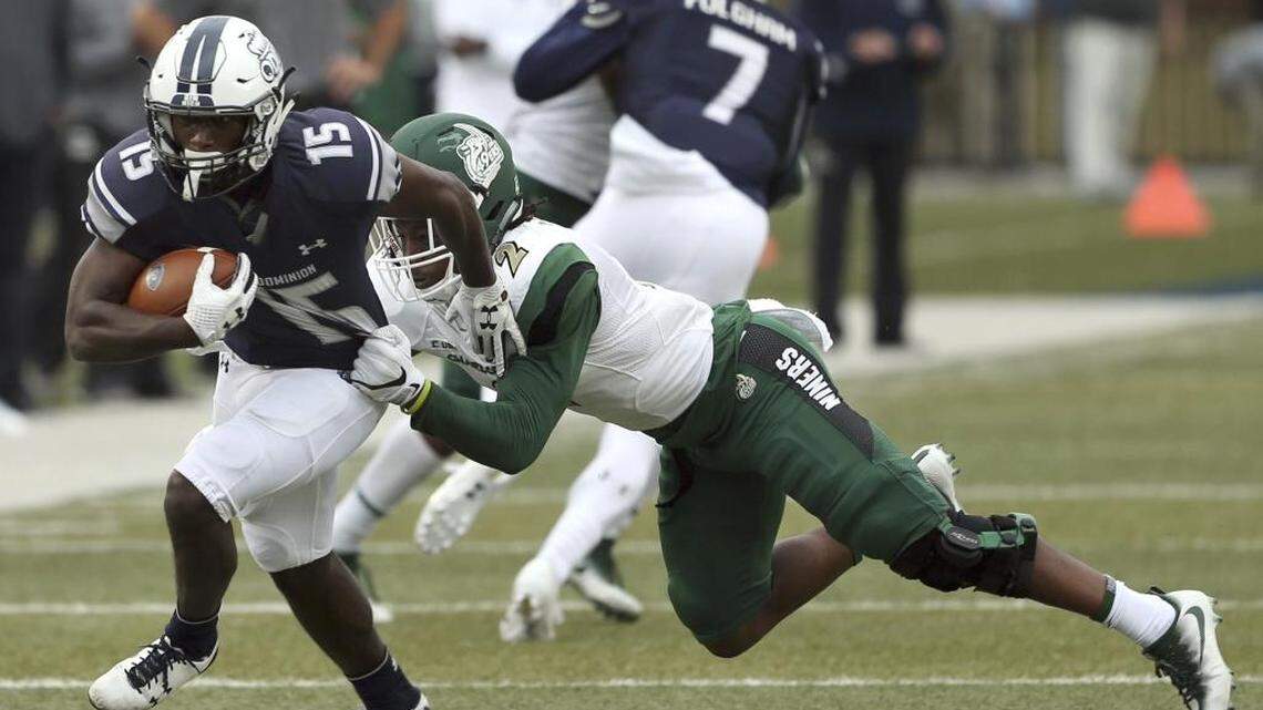 Old Dominion University wide receiver Isaiah Harper drags Charlotte’s Ed Rolle with him for a first down during the first half of Saturday’s game in Norfolk, Va.