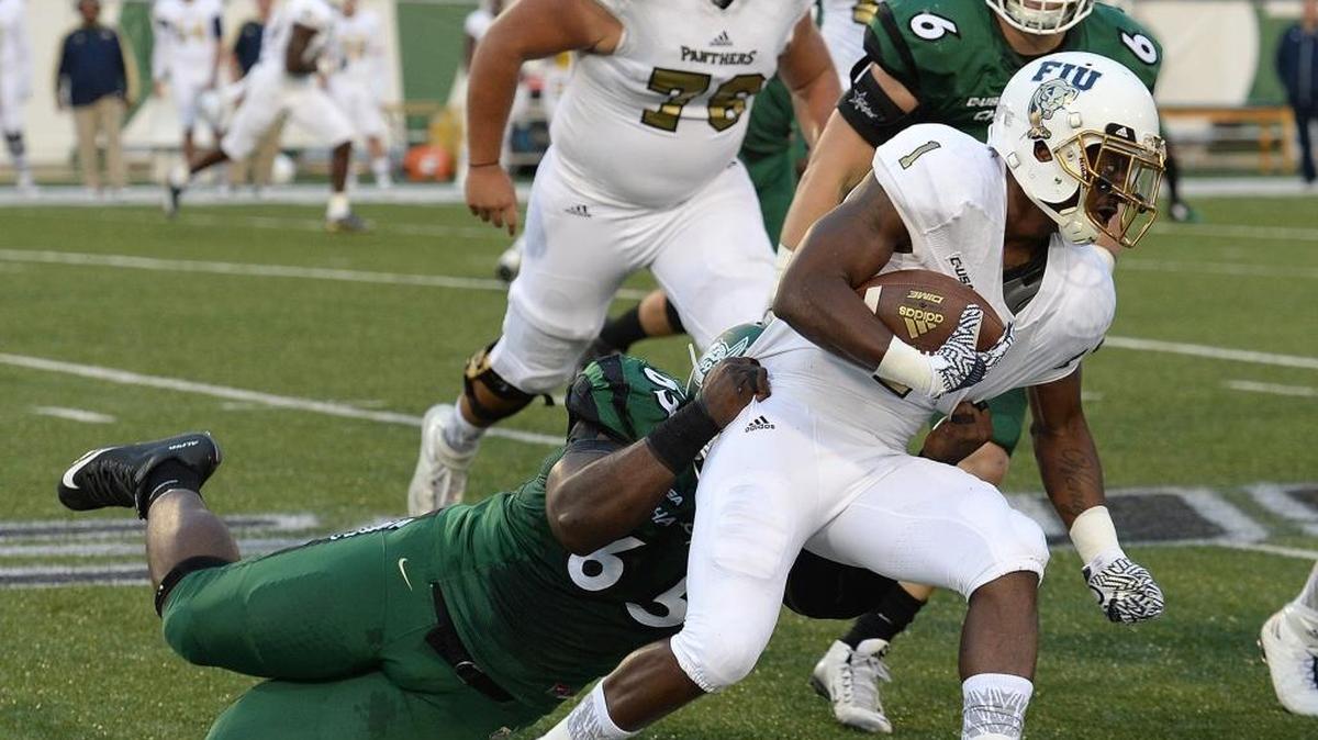 In October, Charlotte 49ers defensive tackle Larry Ogunjobi (left) makes a tackle against Conference USA rival Florida International. Tuesday, the senior was named to the All-Conference USA first team.