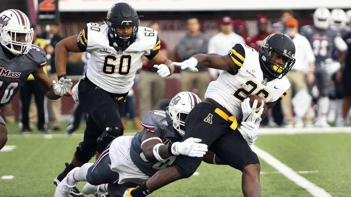 Appalachian State’s Marcus Williams Jr., right, attempts to run for a first down but he is brought down from behind by Massachusetts’ Ali Ali-Musa during the first quarter of Saturday’s game in Amherst, Mass. UMass won 30-27 in two overtimes.