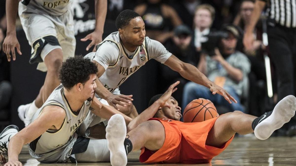 Wake Forest forward Donovan Mitchell, left, and guard Brandon Childress (10) battle Virginia Tech guard Justin Bibbs (10) for a the ball during an NCAA college basketball game Wednesday, Jan. 10, 2018, in Winston-Salem.