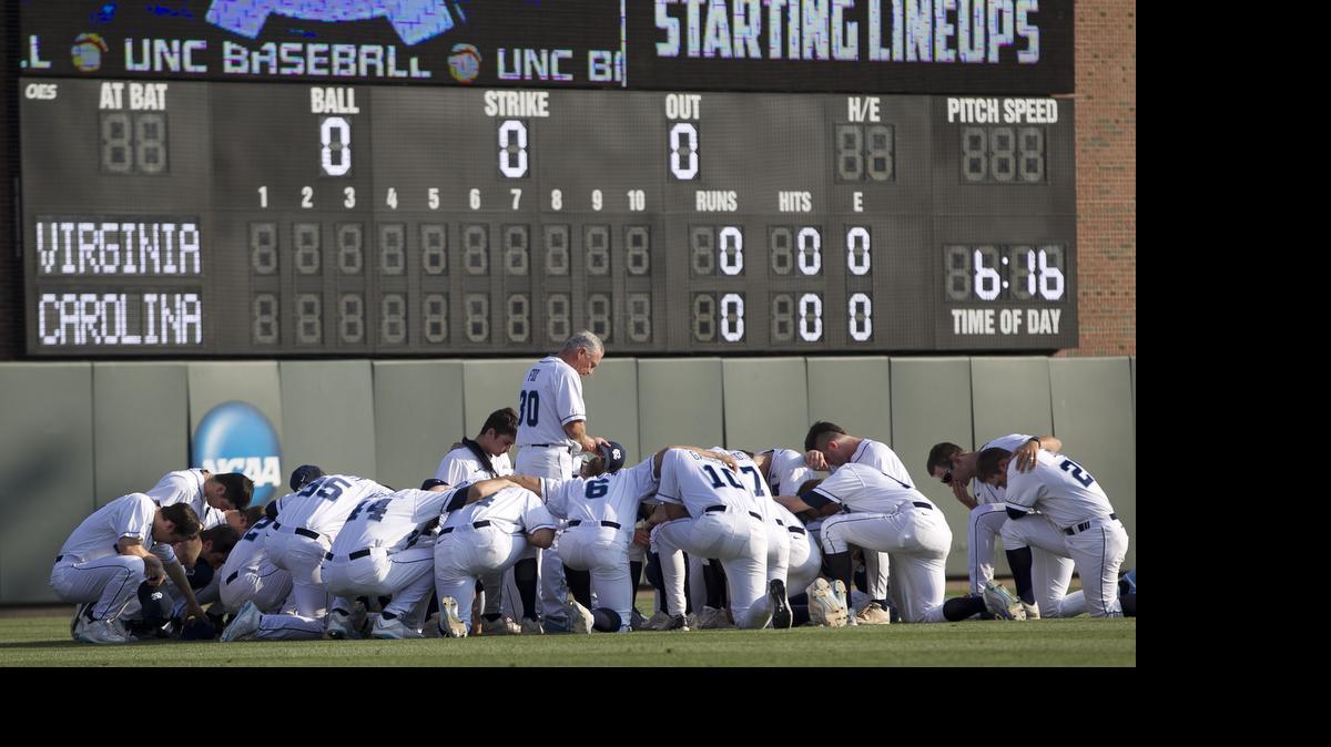 
North Carolina coach Mike Fox and his players gather for prayer in left field of Boshamer Stadium prior to their game against Virginia on Friday, May 15, 2015 in Chapel Hill. 
