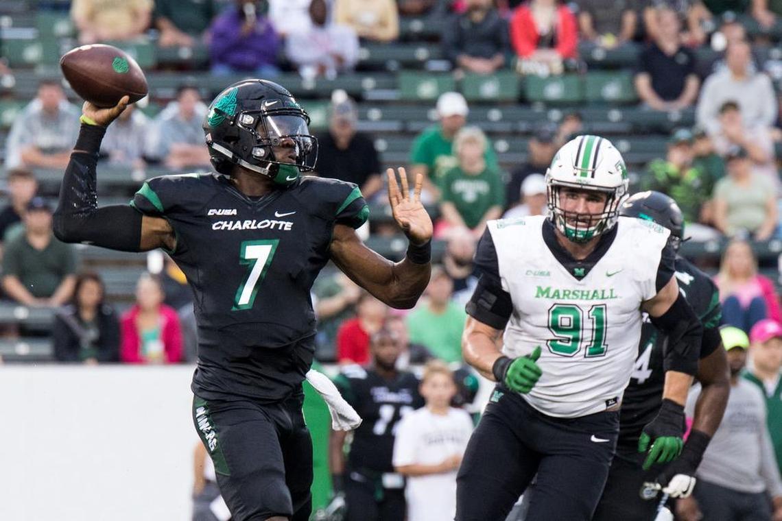 Charlotte 49ers quarterback Hasaan Klugh (7) looks to pass as Marshall defensive lineman Ryan Bee charges in during Saturday’s game at Jerry Richardson Stadium. .