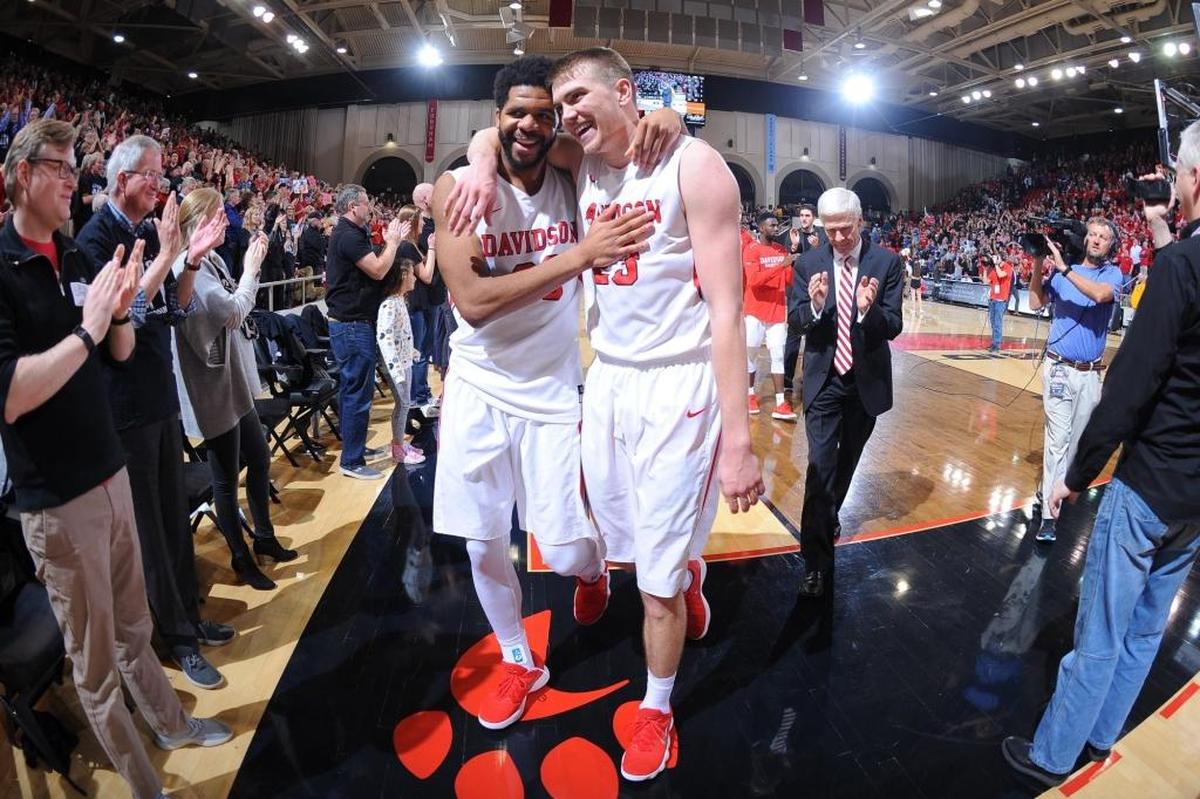 Davidson’s KiShawn Pritchett (20) and Peyton Aldridge (23) celebrate Friday’s upset win over No. 17 Rhode Island.