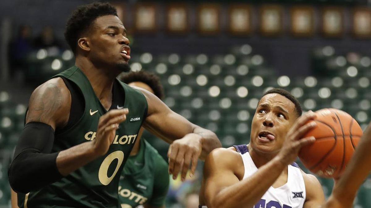 TCU guard Desmond Bane (1) looks for the basket while being guarded by Charlotte center Jailan Haslem (0) during the second half of a Diamond Head Classic opener between the teams Saturday in Honolulu.