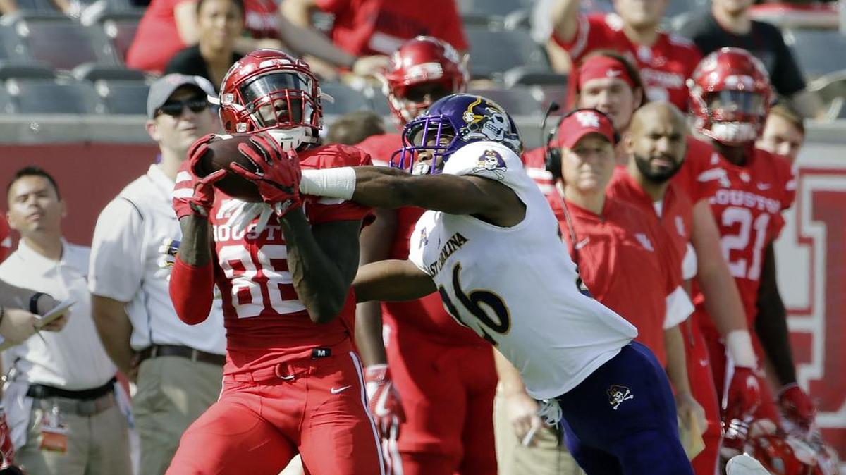 Cougars wide receiver Steven Dunbar (88) makes the catch despite the pressure by East Carolina defensive back Colby Gore during the first half Saturday in Houston.