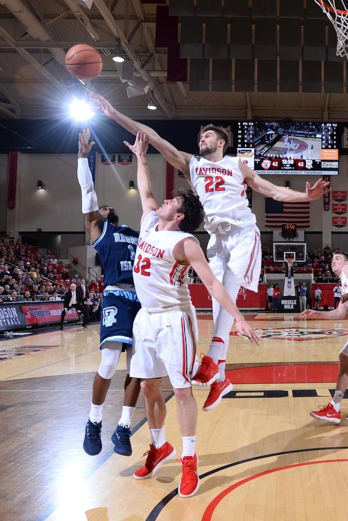 Davidson’s Will Magarity (22) reaches over Rusty Reigel (32) trying to block Rhode Island’s Jeff Dowtin (11) shot early in the second half of Friday’s Atlantic 10 basketball game at Belk Arena. The Wildcats upset the No. 17 Rams, 63-61.