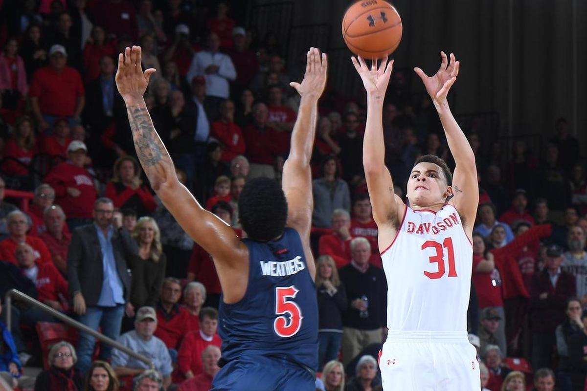 Davidson’s Kellan Grady fires a 3-pointer over Duquesne’s Marcus Weathers late in second half of Saturday’s A-10 men’s basketball game at Belk Arena. Grady scored 17 points in the Wildcats’ 65-61 victory.