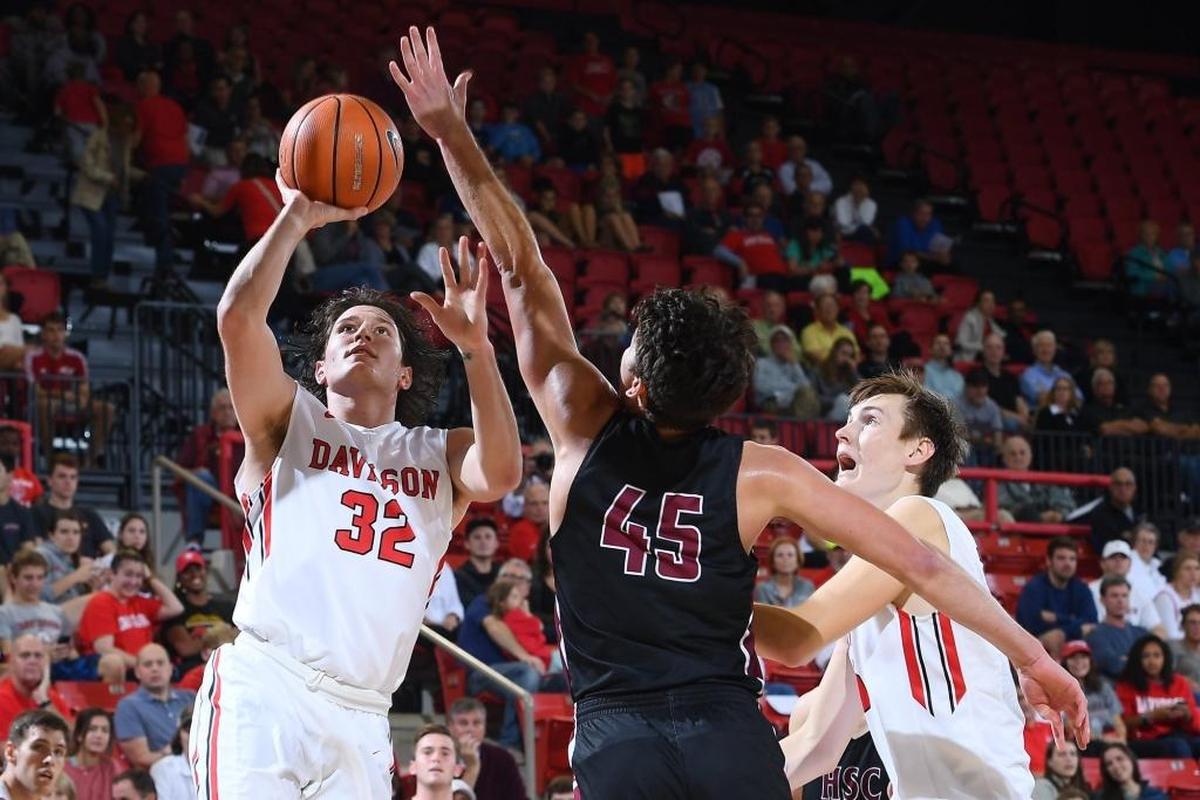Rusty Reigel (32) of Davidson scores on a layup over Drew Scott (45) of Hampden-Sydney during Friday’s nonconference exhibition basketball game at Belk Arena.