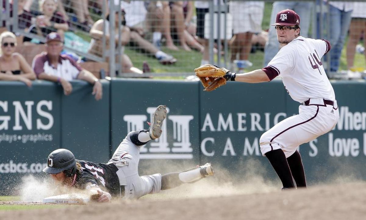 Davidson's Max Bazin (21) safely slides into third base as Texas A&M infielder George Janca (44) looks to make a play elsewhere after missing the tag on Bazin in the 12th inning of Friday’s NCAA college baseball tournament super regional game.