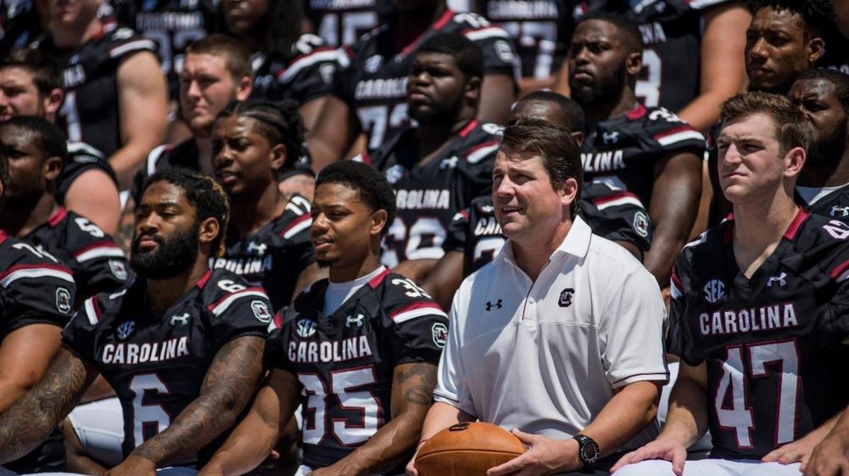 South Carolina football coach Will Muschamp poses with players for a team picture last Sunday during media day at Williams-Brice Stadium. Muschamp is in his first season with the Gamecocks, who were 3-9 last season, 1-7 in the SEC.