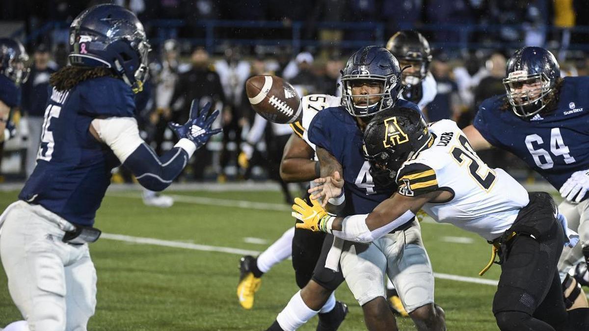 Georgia Southern quarterback Shai Werts (4) pitches to running back Monteo Garrett, left, while under pressure from Appalachian State linebacker Noel Cook (20) during the first half of Thursday’s Sun Belt Conference football game in Statesboro, Ga. Georgia Southern won 34-14, upsetting the No. 25-ranked Mountaineers.