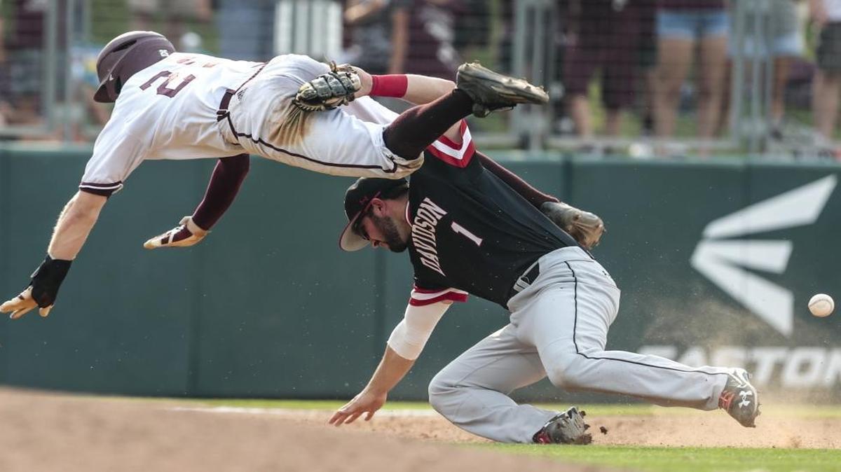 Texas A&M's Austin Homan (25) collides with Davidson infielder Tyler Agard (1) on a grounder by Cole Bedford during the 12th inning of Friday’s NCAA college baseball tournament super regional game. Homan was called out for interference on the play.