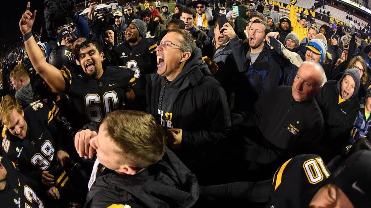 Appalachian State football coach Scott Satterfield, center, celebrates with players and fans after the Mountaineers clinched the Sun Belt East Division title with Saturday’s 21-10 win against Troy. The Mountaineers will play host to Louisiana in next Saturday’s conference championship game at Kidd Brewer Stadium.