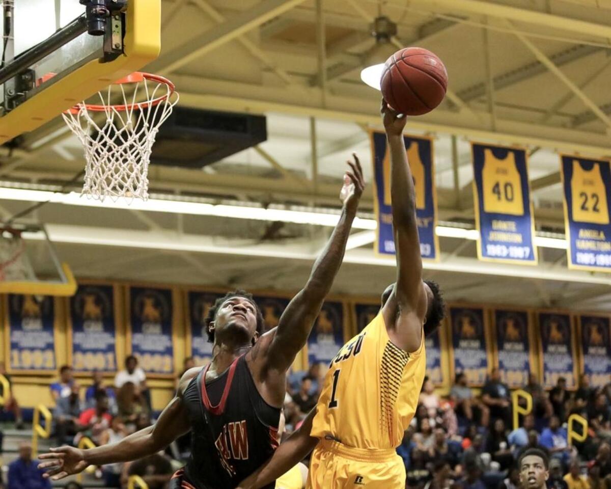 Johnson C. Smith’s Roddric Ross, right, and Shaw's Savon Goodman battle for a rebound. Shaw rallied to beat J.C. Smith, 78-75, Saturday at Brayboy Gymnasium.