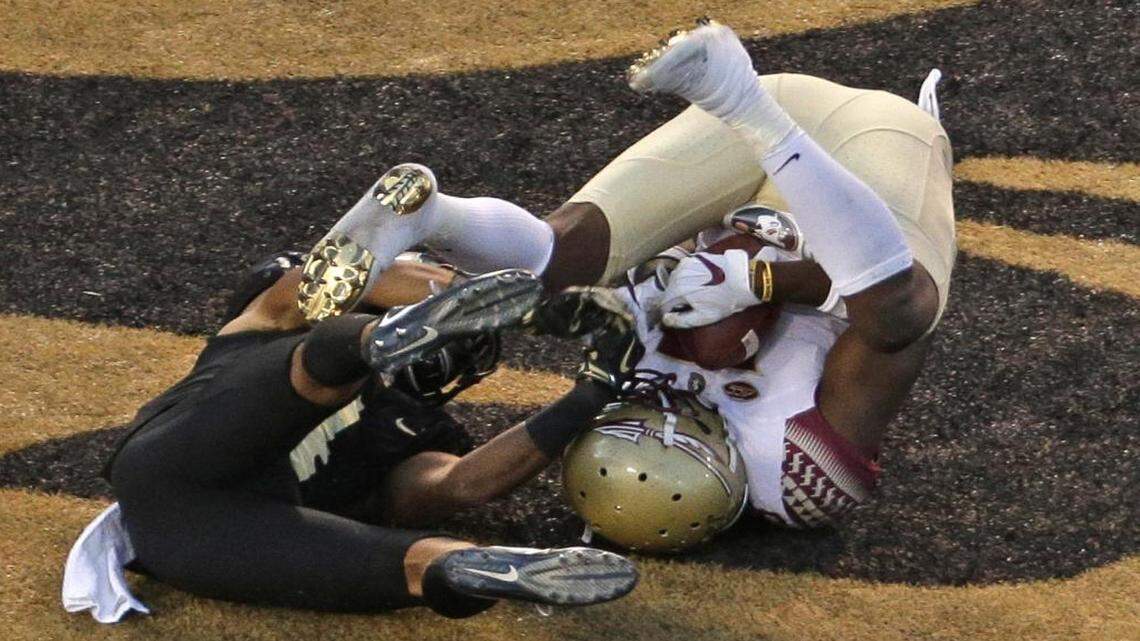 Florida State's Auden Tate, right, catches a touchdown pass as Wake Forest's Amari Henderson, left, defends late in the second half of Saturday’s game in Winston-Salem.