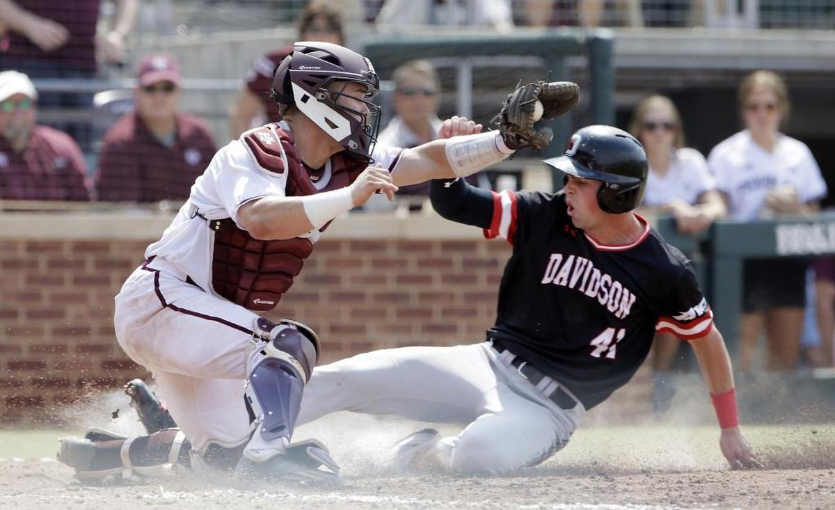 Texas A&M catcher Cole Bedford (54) can't make the tag at the plate as Davidson's Will Robertson (41) scores in the top of the sixth inning of Friday’s NCAA college baseball tournament super regional game.