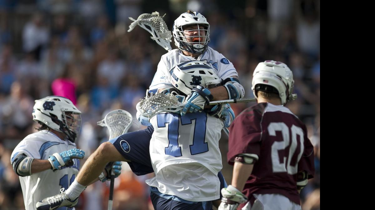 
North Carolina’s Jim Bitter (4) jumps into the arms of teammate Zach Powers (77) after Powers scored in the second period against Colgate during the NCAA Lacrosse Tournament on Sunday, May 10, 2015 in Chapel Hill, N.C. The Tar Heels rolled to a 19-12 victory. 
