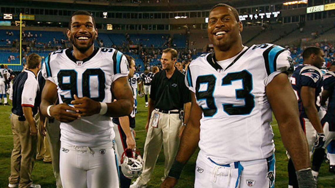 Charlotte Observer file: Carolina Panthers defensive end great Mike Rucker (right) smiles after a game with fellow defensive lineman Julius Peppers (left). Rucker still resides in the Charlotte area and has devoted a lot of his career-after-football to growing the game of flag football.