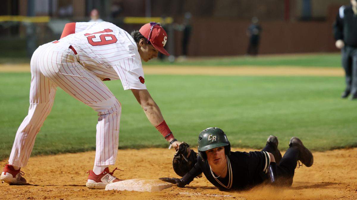 Catawba Ridge’s Jack Shelnutt slides back into first base as South Meck’s Gabe Luke-Judy tries to tag him Wednesday in Charlotte.