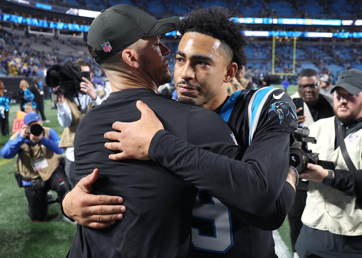 Carolina Panthers head coach Dave Canales, left, hugs quarterback Bryce Young, right, following the teams 34-31 loss to the Los Angeles Rams at Bank of America Stadium on Saturday, January 10, 2026.
