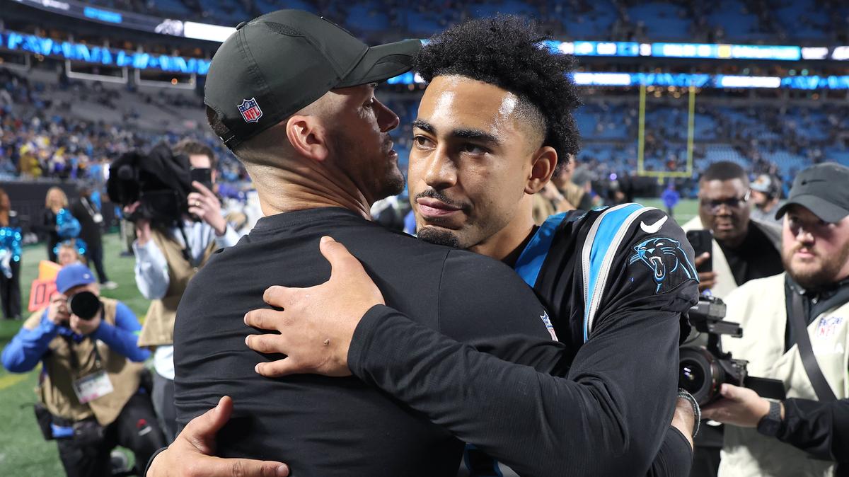 Carolina Panthers head coach Dave Canales, left, hugs quarterback Bryce Young, right, following the teams 34-31 loss to the Los Angeles Rams at Bank of America Stadium on Saturday, January 10, 2026. 