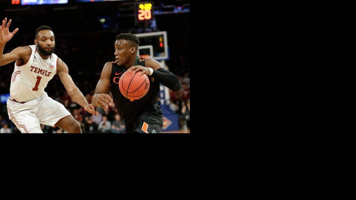 
Miami's Deandre Burnett (1) drives past Temple's Josh Brown (1) during the second half of a semifinal at the NIT college basketball tournament Tuesday, March 31, 2015, in New York. Miami won 60-57.
