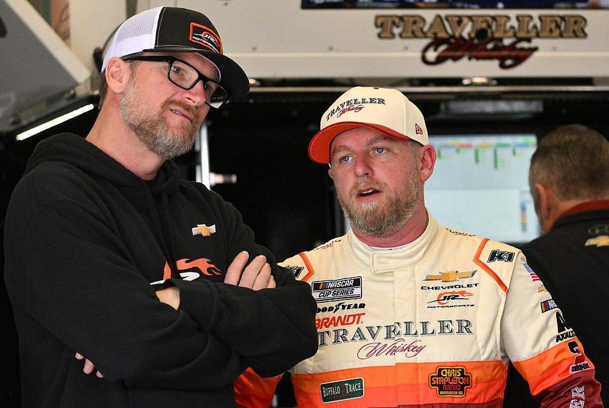 Dale Earnhardt Jr., owner of JR Motorsports, (left) and Justin Allgaier, driver of the No. 40 Traveller Whiskey Chevrolet, talk in the garage area during practice for the NASCAR Cup Series Daytona 500 at Daytona International Speedway on Feb. 11, 2026, in Florida.